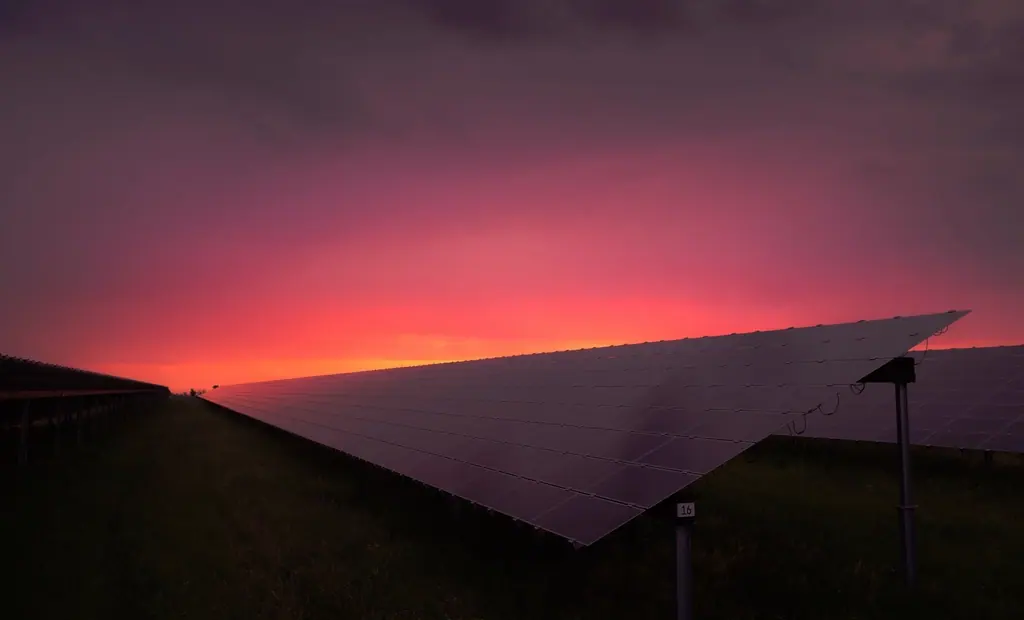 Solarmodulreihe im Abendrot unter einem glühenden Himmel